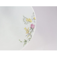 Zbliżenie na krawędź białej salaterki 17 cm G763 YVETTE marki Chodzież. Porcelanowe naczynie ozdobione delikatnym, wielobarwnym motywem polnych kwiatów w stylu