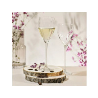 Dwa eleganckie kieliszki do wina Perla marki Krosno Glass o pojemności 280 ml. Jeden wypełniony białym winem, ustawione na drewnianych podstawkach wśród