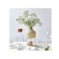 Wazon Krosno Glass S.A. o wysokości 25 cm z serii Home. Szklane naczynie z matowym, beżowym wykończeniem w górnej części, wypełnione bukietem gipsówki.