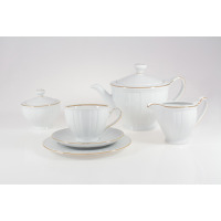 Zestaw do herbaty Ćmielów 3610 Oktawa ze złotym paskiem. Biała porcelana z delikatnym żłobkowaniem, obejmująca dzbanek, cukiernicę, mlecznik oraz filiżankę ze