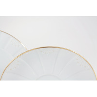 Zbliżenie na białe porcelanowe talerzyki z zestawu herbacianego Ćmielów G311 Oktawa. Brzegi naczyń zdobi złota linia oraz subtelny, geometryczny wzór kwiatowy.