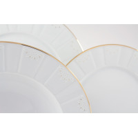 Zbliżenie na białe talerze z zestawu obiadowego Ćmielów G311 Oktawa. Porcelanowe naczynia zdobi subtelny, geometryczny wzór kwiatowy oraz eleganckie, złote
