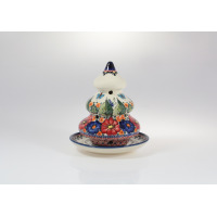 Ceramiczny lampion choinka Bolesławiec o wysokości 14,6 cm. Ręcznie malowany wzór w kwiaty i motyle na kremowym tle, z ażurowymi otworami na podstawce.