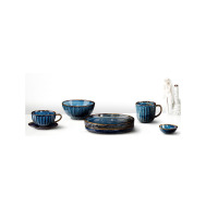 Zestaw ceramicznej zastawy stołowej Verlo Deep Blue w odcieniach głębokiego błękitu z brązowymi rantami. Widoczny talerz płytki 25 cm, filiżanka, miska i kubek.