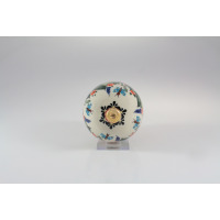 Ozdoba choinkowa Bolesławiec 11 cm GU-1808 w widoku od góry. Ceramiczna bombka z charakterystycznym wzorem w niebieskie motyle i kwiaty oraz złotą zawieszką.