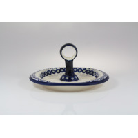 Ceramiczna tacka Bolesławiec 166A o wymiarach 18,4 x 22,6 cm z charakterystycznym wzorem pawich oczek. Naczynie posiada centralny uchwyt z otworem, widok z