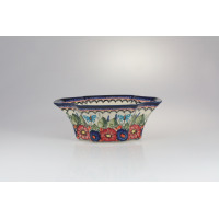 Ceramiczna salaterka Bolesławiec 149AR o wymiarach 15,8 x 23 cm. Naczynie o falistym brzegu zdobi ręcznie malowany wzór w czerwone kwiaty, niebieskie motyle i