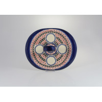 Owalna ceramiczna tacka Bolesławiec 149AR o wymiarach 18,4 x 22,6 cm. Ręcznie malowana w tradycyjny wzór GU-1501 z niebieskimi, czerwonymi i czarnymi motywami.