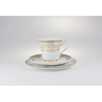 Porcelanowy zestaw kawowy Ćmielów G670 Margaret. Filiżanka na spodku i talerzyku deserowym, zdobiona eleganckim złotym ornamentem roślinnym na białym tle.