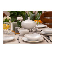 Elegancki serwis obiadowy Dalia Złota linia marki Chodzież. Biała porcelana z delikatnym żłobkowaniem i złotym wykończeniem, ustawiona na stole z wazą i
