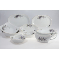 Serwis obiadowy Ćmielów G559 Rococo dla 6 osób. Biała porcelana z delikatnym reliefem i motywem fiołków, obejmująca półmiski, salaterki oraz sosjerkę na jasnym