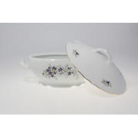 Waza z serwisu obiadowego G559 Rococo marki Ćmielów. Biała porcelana z tłoczonymi zdobieniami i motywem fioletowych fiołków, widoczna z otwartą pokrywą obok