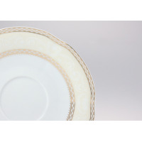Zbliżenie na krawędź spodka z bulionówki Ćmielów E363 Bolero. Biała porcelana z kremowym brzegiem, zdobiona subtelnym ornamentem roślinnym i złotym