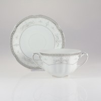 Porcelanowa bulionówka 0,30 l ze spodkiem Ćmielów E361 Bolero. Białe naczynie z dwoma uszkami i eleganckim, srebrnym zdobieniem w kwiatowe wzory na krawędziach.