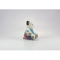 Ceramiczna figurka Miś Bolesławiec 149AR z profilu. Biała powierzchnia ozdobiona jest charakterystycznym, ręcznie malowanym motywem kwiatowym i niebieską