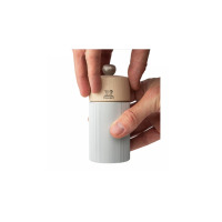Dłonie trzymające młynek do soli Peugeot Natural Aluminium Line 12 cm. Jasny drewniany element z logo lwa łączy się z żebrowanym, aluminiowym korpusem.