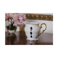 Biały porcelanowy dzbanek do mleczka Ćmielów G539 Alaska Dama Kier z eleganckim złotym uchwytem i rantem. Na korpusie widnieje geometryczny wzór trzech