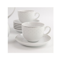 Zestaw kawowy Classic Carmen WA-91 marki Waza. Biała porcelanowa filiżanka z subtelnym, kropkowanym wzorem i srebrnym wykończeniem na spodku, w tle stos naczyń.