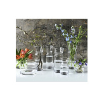 Kolekcja szklanych naczyń Krosno Glass, w tym dzbanek 750 ml Nepenthes, ustawionych na białym blacie. Przezroczyste wazony i naczynia wypełnione kwiatami i