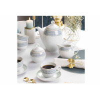 Zestaw kawowy dla 12 osób Classic Murano od Waza. Biała porcelana z niebiesko-zielonym geometrycznym wzorem i złotym wykończeniem, ustawiona na stole z