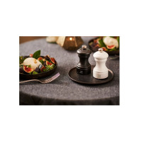 Zestaw dwóch młynków do soli i pieprzu Peugeot Bistro 10 cm w kolorze czarnym i białym na ciemnym talerzyku, obok talerza z sałatką z figami i serem na szarym