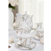 Elegancki garnitur do kawy Ćmielów 7830 ROCOCO Anna dla 6 osób. Biała porcelana ze złotymi zdobieniami w stylu rokoko, ustawiona na stole z kwiatami.