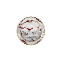 Sosjerka z serwisu obiadowego 0040 Rococo marki Ćmielów. Biała porcelana z bordowym zdobieniem i złoceniami, ustawiona na pasującym talerzyku, widok z góry.