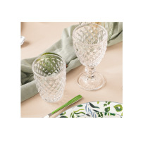 Kieliszek 200 ml DIAMOND marki Amefa oraz pasująca szklanka z przezroczystego szkła o geometrycznym, diamentowym wzorze na beżowym obrusie z zieloną serwetką.