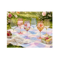 Kolorowe kieliszki 470 ml Joyful Mix od Glasmark na piknikowym kocu. W szklanych naczyniach o różnych barwach znajdują się owoce, napoje i dekoracyjne gałązki.