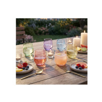 Zestaw 6 kolorowych szklanek niskich 310 ml Joyful Mix marki Glasmark na drewnianym stole w ogrodzie. Szklane naczynia w pastelowych odcieniach otoczone