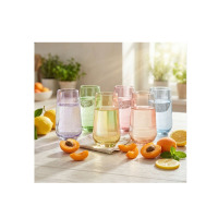 Zestaw sześciu kolorowych szklanek wysokich 430 ml Joyful Mix marki Glasmark na jasnym stole, otoczonych świeżymi cytrynami i połówkami moreli w słonecznym