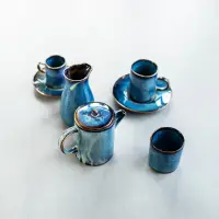 Zestaw ceramiczny Verlo Deep Blue: dzbanek do kawy 650 ml, dzbanek na mleko oraz trzy filiżanki w odcieniach głębokiego błękitu z rustykalnym wykończeniem.