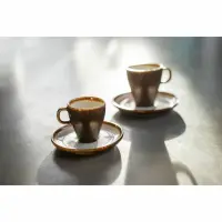 Dwie brązowe filiżanki do espresso 90 ml Slow marki Verlo na pasujących spodkach, ustawione na szarym blacie w świetle słonecznym podkreślającym ich fakturę.