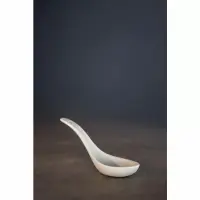 Biała porcelanowa łyżka obiadowa Verlo o długości 12,5 cm, ustawiona pod kątem na ciemnym, matowym tle, prezentująca minimalistyczny i elegancki design.