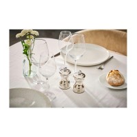 Srebrne młynki do pieprzu Peugeot Bistro Shiny o wysokości 10 cm na nakrytym stole, obok kieliszków, wazonu z kwiatami i pieczywa. Elegancka zastawa stołowa.