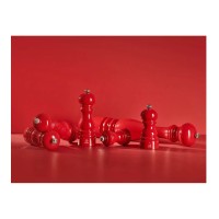 Czerwone młynki do soli i pieprzu Peugeot Paris Red Passion w różnych rozmiarach, ustawione pionowo i leżące na jednolitym czerwonym tle. Widoczne logo marki.