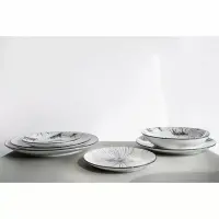 Zestaw talerzy Verlo Wild na szarym blacie. Po lewej stos talerzy płytkich 27 cm z motywem zwierzęcym, po prawej głębokie talerze, a na środku talerzyk