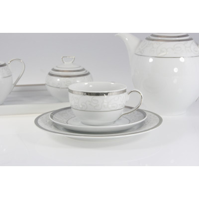 Elegancki garnitur do kawy Chodzież E606 Yvonne. Zestaw kawowy dla 12 osób z białej porcelany ze srebrnym zdobieniem, widoczna filiżanka ze spodkiem i