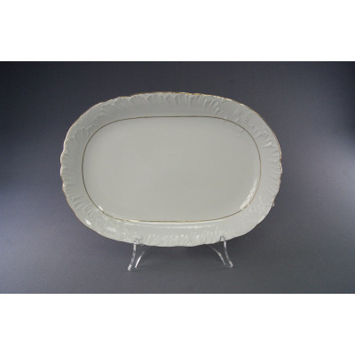 Biały, porcelanowy półmisek owalny 29 cm z kolekcji 3604 Rococo marki Ćmielów. Naczynie posiada delikatne tłoczenia na brzegach oraz subtelne złote wykończenie.