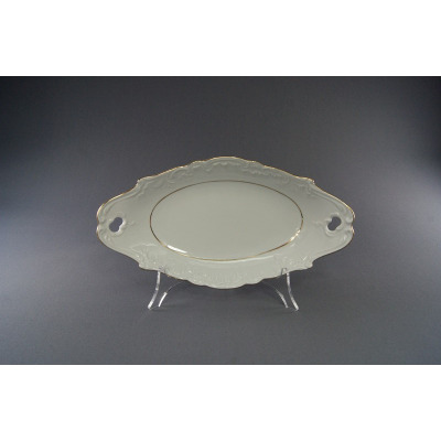 Owalna rawierka 25 cm z kolekcji ROCOCO marki Ćmielów. Biała porcelana z delikatnym reliefem na brzegach, wykończona złotą linią, ustawiona na przezroczystym