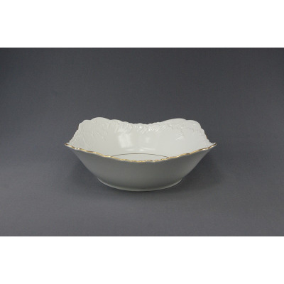Biała salaterka kwadratowa 24 cm 3604 Rococo marki Ćmielów. Porcelanowe naczynie o falistych brzegach z delikatnym złotym zdobieniem, widok z profilu na szarym