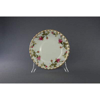 Talerz deserowy 17 cm B013 Iwona marki Chodzież z białej porcelany, zdobiony delikatnym motywem różanych pąków i złoconym, falistym brzegiem na przezroczystym