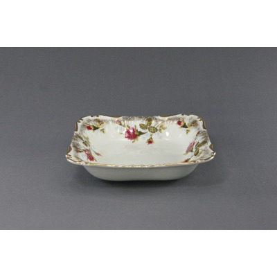 Kwadratowa salaterka Chodzież Iwona B013 o średnicy 21 cm z białej porcelany, ozdobiona delikatnym motywem róż i złotym wykończeniem brzegów, ujęta z profilu.