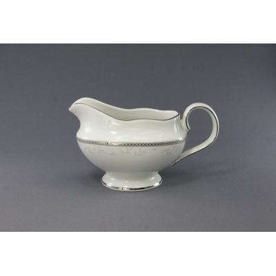 Biała porcelanowa sosjerka Ćmielów B601 Astra o pojemności 0,50 l. Eleganckie naczynie z delikatnym motywem roślinnym i srebrnym zdobieniem na krawędziach.