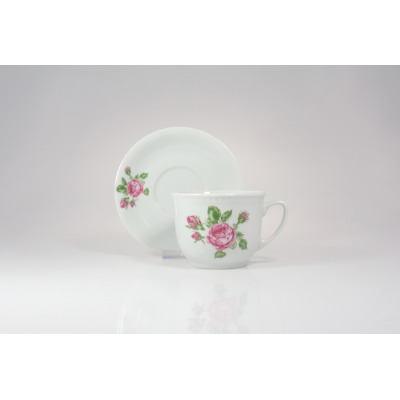 Biały kubek 300 ml ze spodkiem Wiedeń 3999D marki Lubiana. Porcelanowe naczynia zdobione delikatnym motywem różowych kwiatów z zielonymi listkami na jasnym tle.