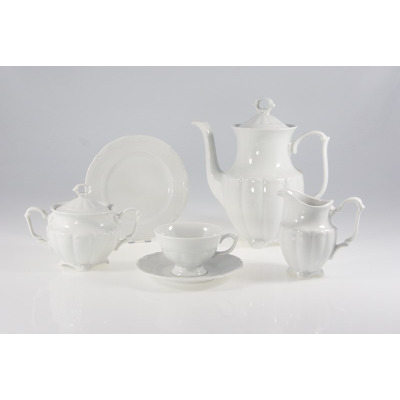 Biały zestaw kawowy Maria Teresa marki Chodzież. Komplet porcelany z tłoczonymi zdobieniami obejmuje dzbanek, cukiernicę, mlecznik, filiżankę ze spodkiem i