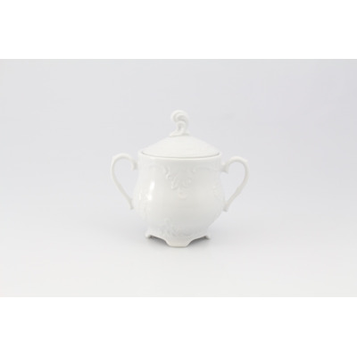 Biała cukiernica 0,40 l z serii Rococo marki Ćmielów. Eleganckie naczynie porcelanowe z ozdobnymi tłoczeniami, dwoma uchwytami i pokrywką, widok z przodu.