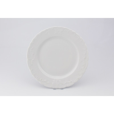 Biały talerz płytki 26 cm z serii Rococo marki Ćmielów. Klasyczna porcelana o okrągłym kształcie z ozdobnym, reliefowym zdobieniem na falistym rancie.