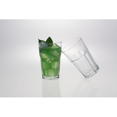 Szklanki ARAS 300 ml od LAV w zestawie 6 sztuk. Jedna szklanka wypełniona zielonym napojem z lodem i listkami mięty, obok druga pusta szklanka ustawiona pod