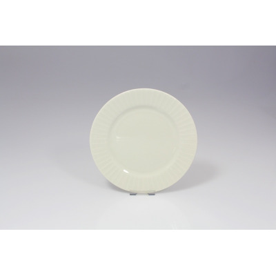 Talerz deserowy 17 cm Metropolis od RAK Porcelain w kolorze kremowym. Okrągłe naczynie z eleganckim, żłobionym wzorem na szerokim rancie, widok z przodu.